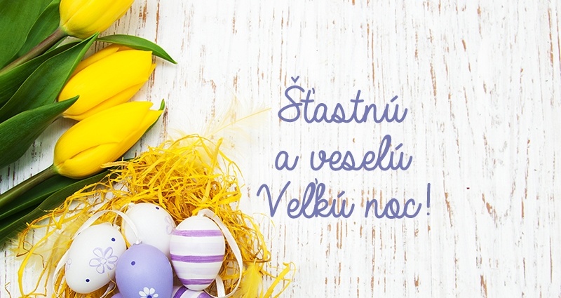Fialovo biele veľkonočné vajíčka uložené v žltom hniezdočku z dekoratívnej rafie vedľa žlté tulipány na svetlom pozadí. V strede fotografie je nápis Šťastnú a veselú Veľkú noc